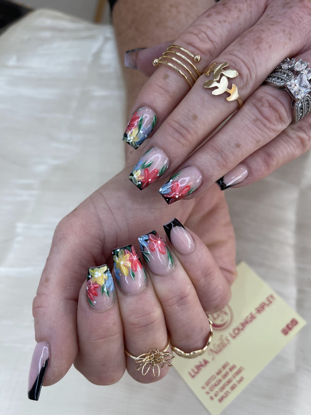 Hand-painted floral nail art with black tips
