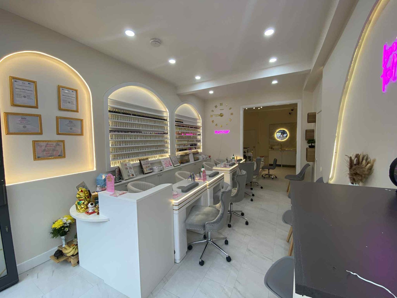 Inside the lounge: lit shelves of gel colours, white nail desks and grey chairs